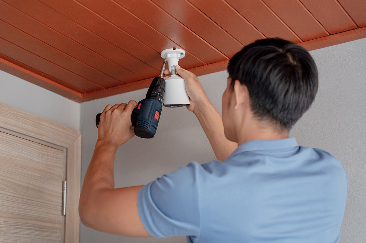 Technician installing an IP CCTV camera in a modern apartment